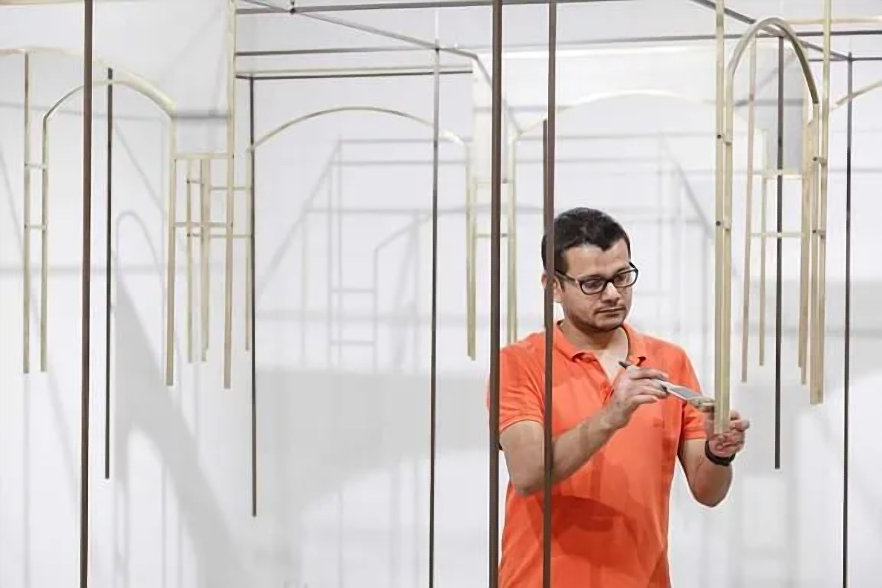 The artist installing slender brass-toned elements for the CELINE Art Project
